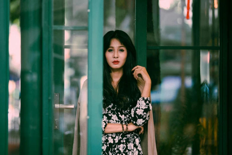 a woman standing in front of a green door, a black and white photo, pexels contest winner, realism, gorgeous young korean woman, floral clothes, she has a distant expression, ulzzang