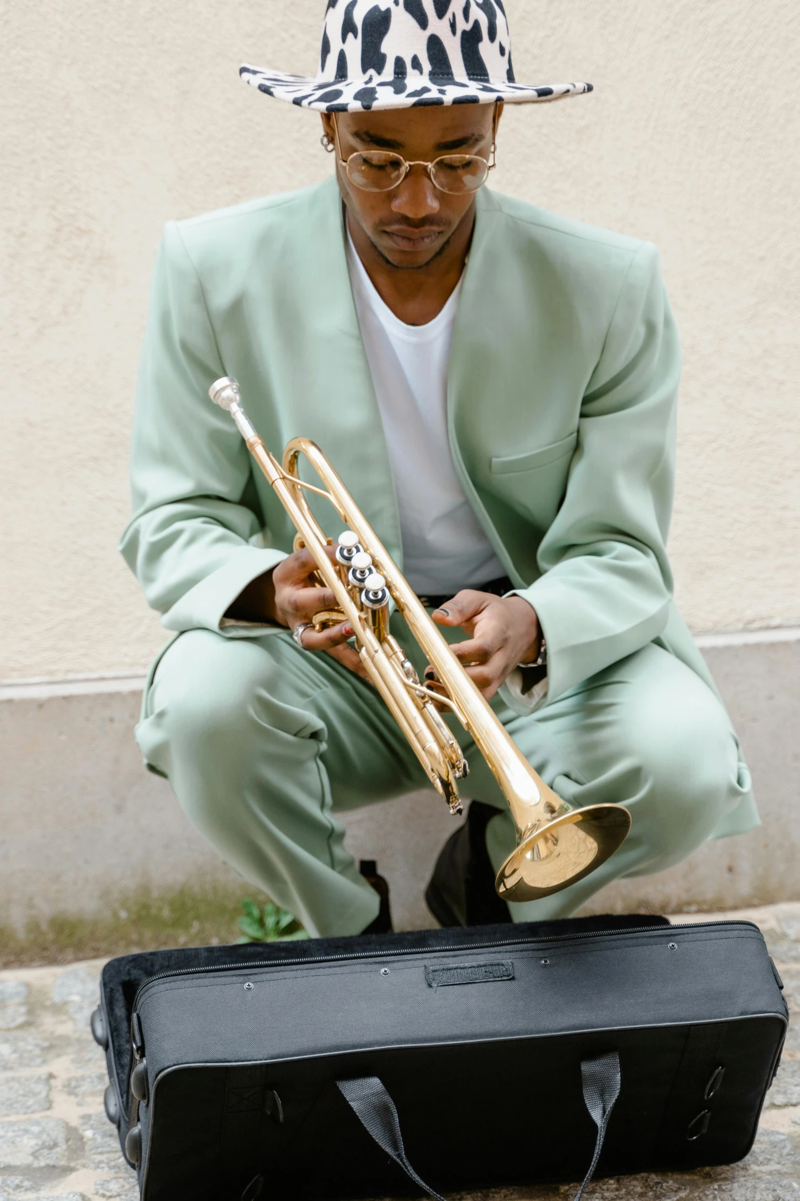 a man sitting on the ground with a trumpet, pexels contest winner, harlem renaissance, gold suit, mint condition, as well as scratches, 2 0 0 5