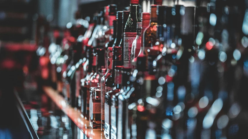 a row of wine bottles sitting on top of a bar, a screenshot, pexels contest winner, reds, booze, thumbnail, curated collection