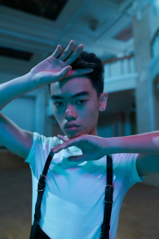 a man wearing suspenders and a white shirt, an album cover, inspired by Ding Yunpeng, pexels contest winner, realism, bisexual lighting, in a fighting pose, ( ( theatrical ) ), detailed face of a asian boy