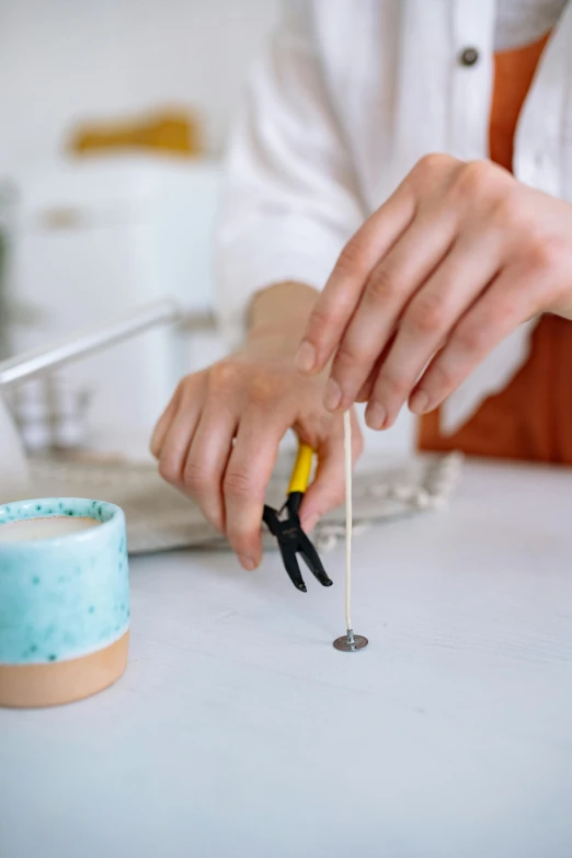 a close up of a person holding a pair of scissors, on a candle holder, ceramics, frying nails, thumbnail