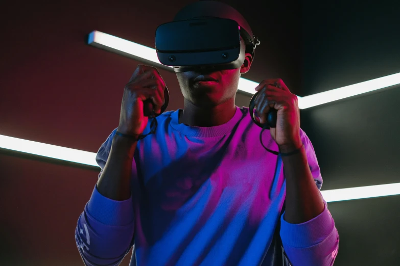 a man wearing a virtual reality headset in front of neon lights, trending on pexels, afrofuturism, oculus quest 2, navy, standing in a dimly lit room, he wears dark visors