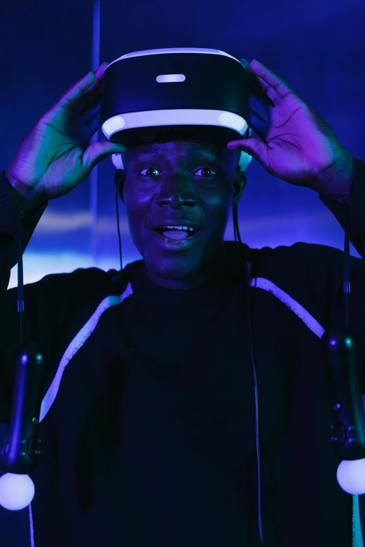 a man wearing a virtual reality headset in a dark room, inspired by Ay-O, afrofuturism, looking happy, young thug, halo above head, adut akech