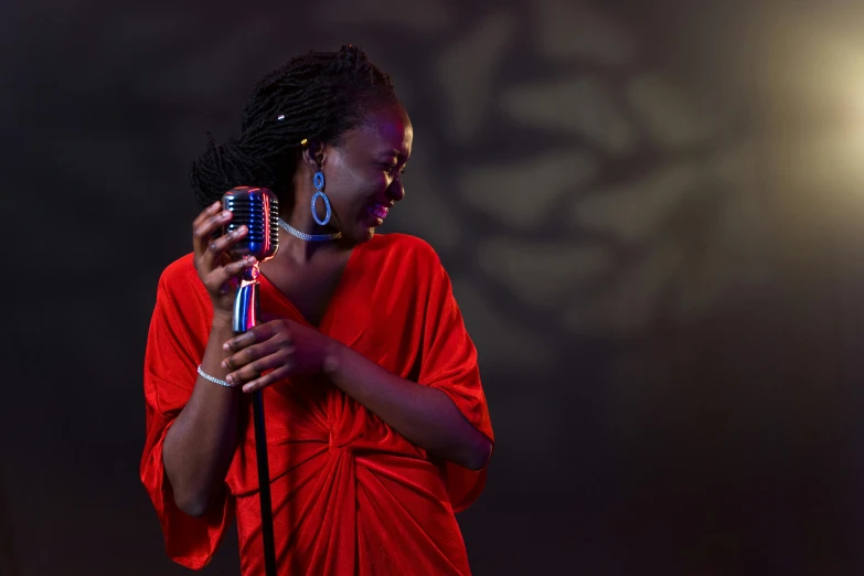 a woman in a red dress holding a microphone, by Ingrida Kadaka, pexels contest winner, dark skinned, blues, coloured, mamou - mani