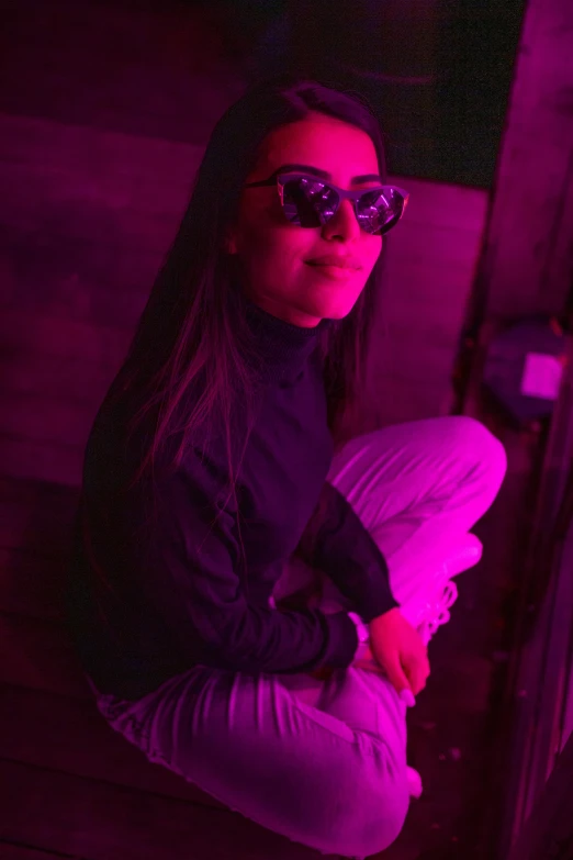 a woman sitting on the ground in front of a purple light, neon sunglasses!, profile pic, indoor picture, infp young woman