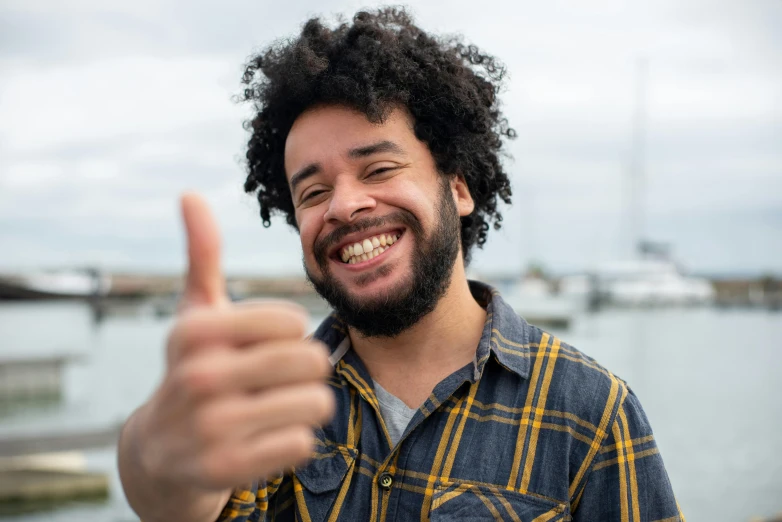 a close up of a person giving a thumbs up, pexels contest winner, figuration libre, black curly beard, smiling male, mixed race, slight overcast