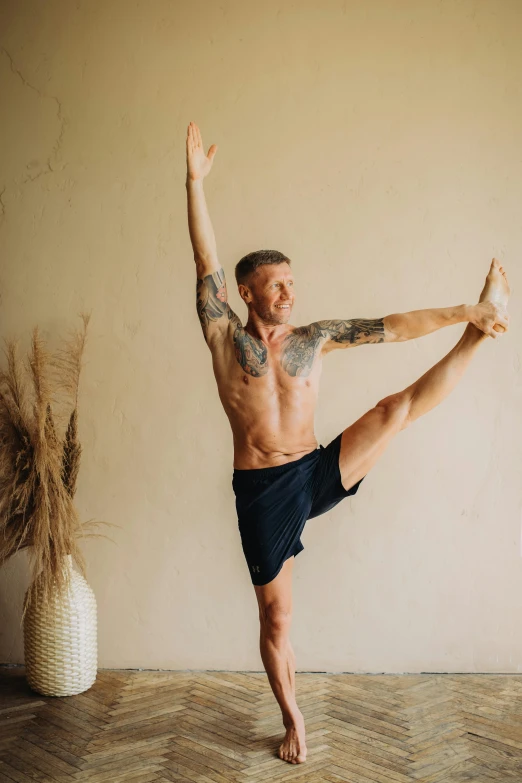 a man standing on one leg in a yoga pose, a photo, by Jessie Alexandra Dick, lachlan bailey, seasonal, sweaty, 4 0 years old