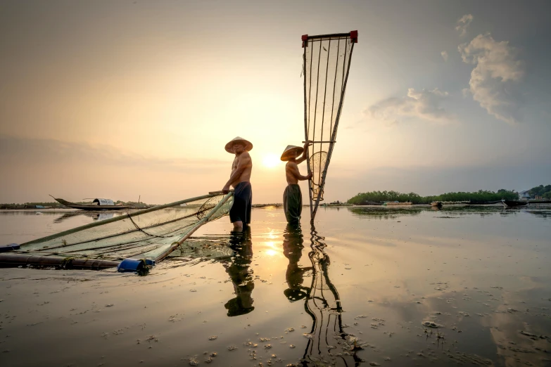 a couple of people that are standing in the water, by Fei Danxu, pexels contest winner, fisherman, late afternoon, slide show, nets