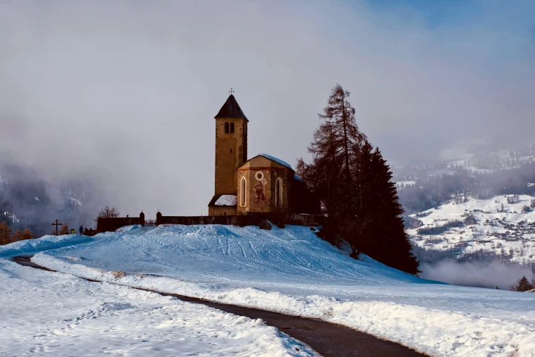 a church sitting on top of a snow covered hill, pexels contest winner, romanesque, beige, snowy italian road, profile image, skiing