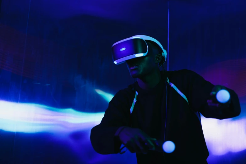 a man wearing a virtual reality headset in a dark room, pexels, afrofuturism, dramatic white and blue lighting, avatar image, purple ambient light, taken with sony alpha 9