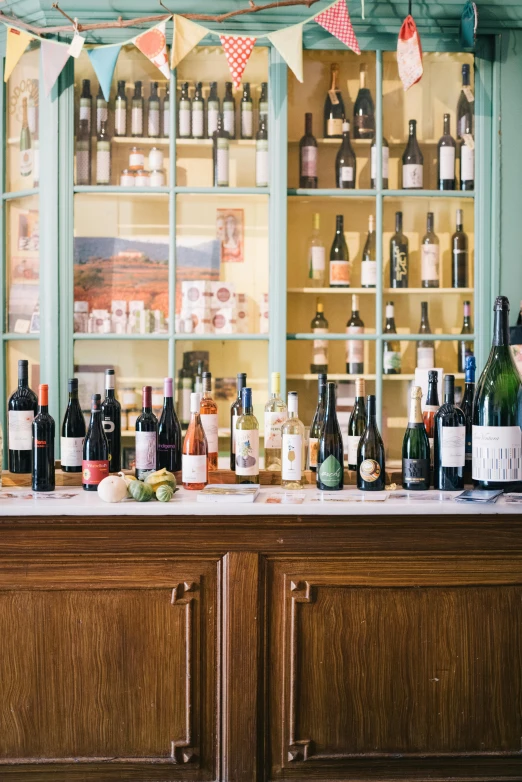 a bar filled with lots of bottles of wine, by Carey Morris, square, ingredients on the table, mediterranean, lined up horizontally