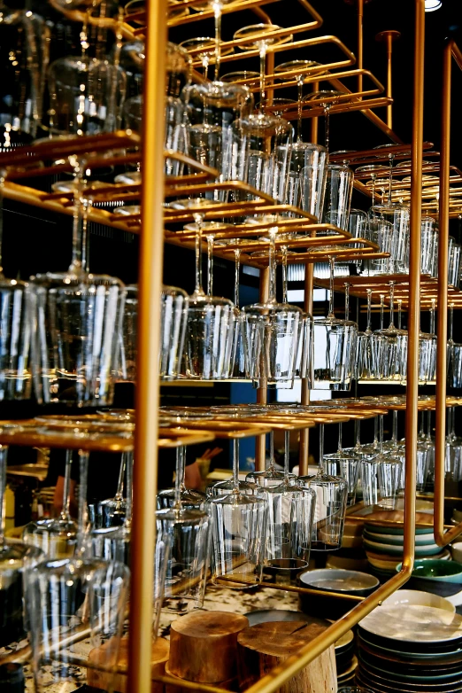 a room filled with lots of glasses and plates, by Rube Goldberg, kinetic art, gold glasses, rack, industrial photography, transparent