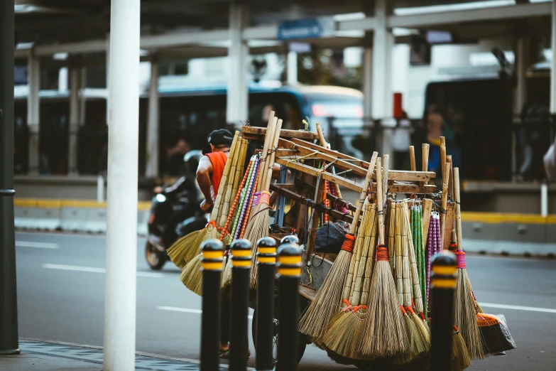 a person on a scooter with brooms on the back, pexels contest winner, mingei, piled around, avatar image, kuala lumpur, kombi