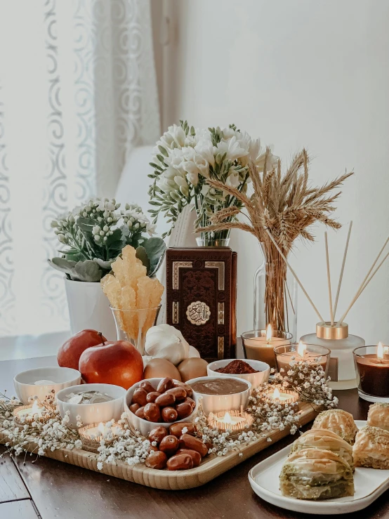 a wooden table topped with plates of food and candles, inspired by Riad Beyrouti, pexels contest winner, hurufiyya, fruit and flowers, background image, full body photo, islamic