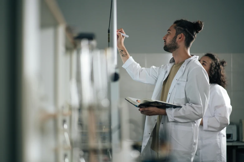 a man in a lab coat writing on a clipboard, trending on pexels, academic art, iv pole, lachlan bailey, profile image, instagram photo