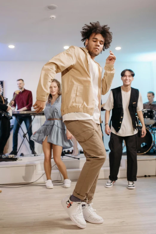 a group of people that are standing in a room, an album cover, trending on pexels, happening, he is dancing, wearing casual clothing, ( ( theatrical ) ), slide show