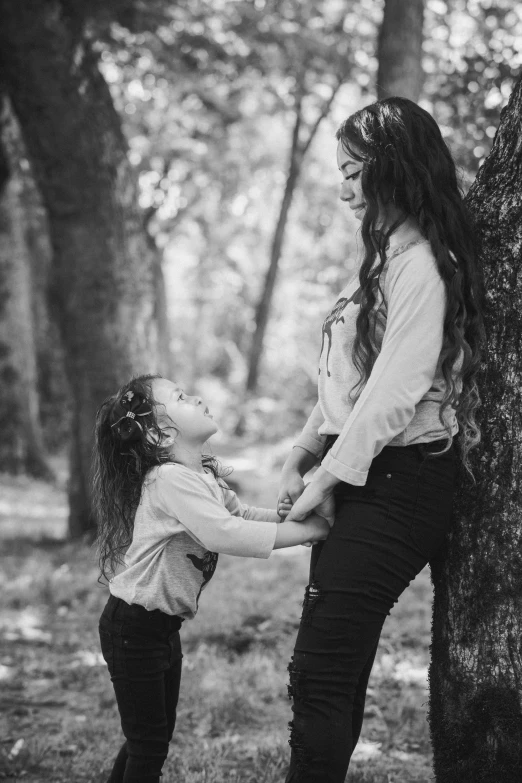 a woman standing next to a little girl near a tree, a black and white photo, by Felix-Kelly, pexels contest winner, ariana grande photography, 15081959 21121991 01012000 4k, both laughing, mother