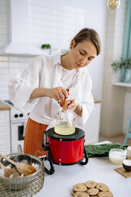 a woman is making cookies in the kitchen, by Julia Pishtar, shutterstock, renaissance, congas, square, blender, japanese model