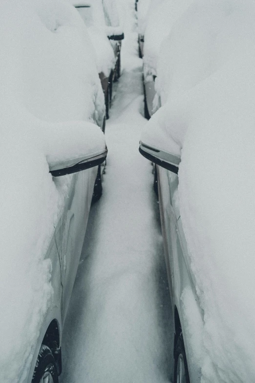 a row of parked cars covered in snow, an album cover, by Anato Finnstark, trending on unsplash, stairways, extreme narrow, digging, chairlifts