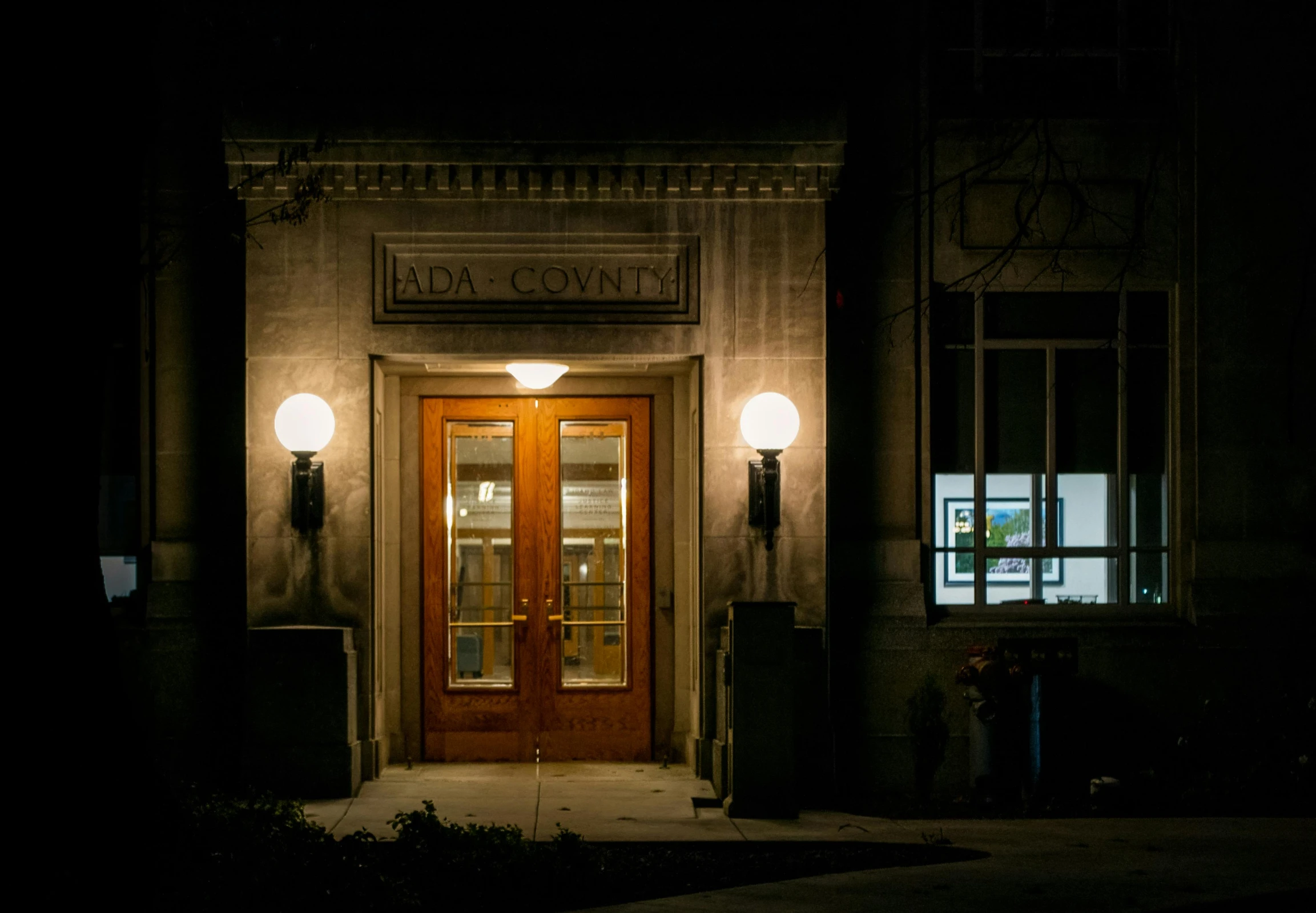 the front door of a building lit up at night, by Joe Stefanelli, old library, lowkey lighting, taken in the early 2020s, lucas graziano