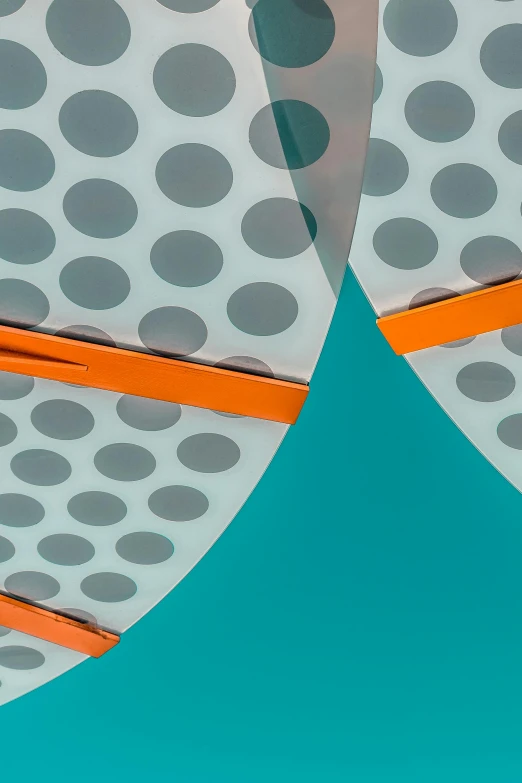 a pair of scissors sitting on top of a piece of paper, inspired by Herbert Bayer, trending on unsplash, conceptual art, orange and teal, perforated metal, viewed from below, parasols