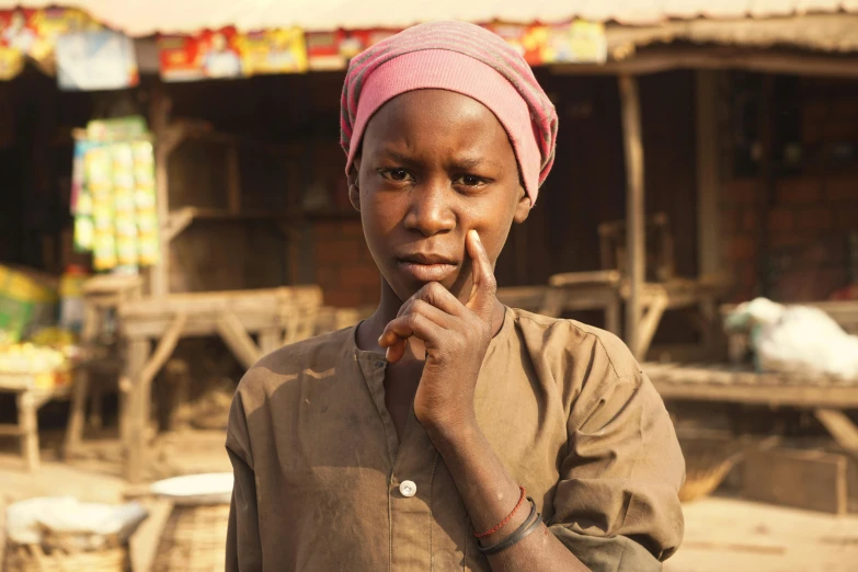 a woman in a pink turban poses for a picture, pexels contest winner, hurufiyya, adut akech, looking confused, in a village, black teenage girl