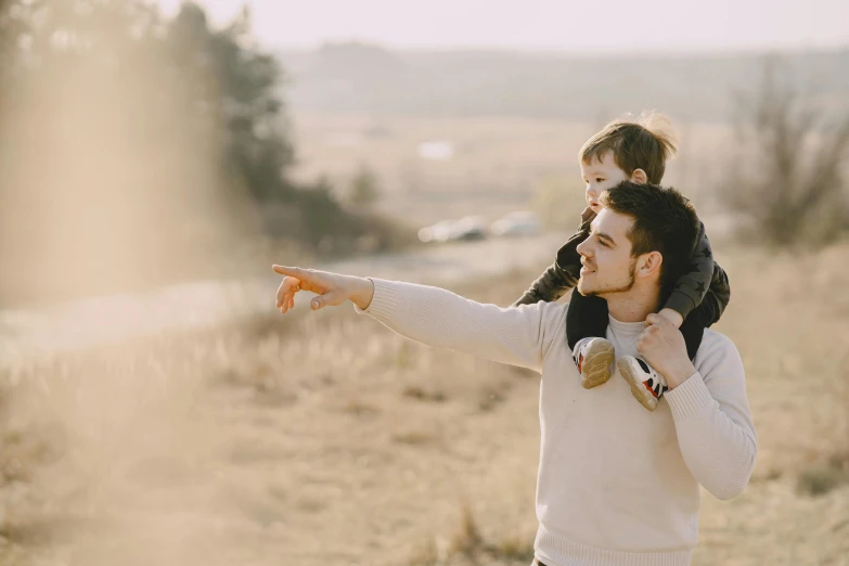 a man holding a little girl on his shoulders, pexels, symbolism, avatar image, pointing, nature outside, handsome man