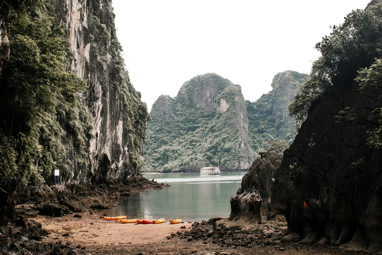 a group of kayaks sitting on top of a beach next to a body of water, pexels contest winner, karst pillars forest, hoang lap, a cozy, an abandoned