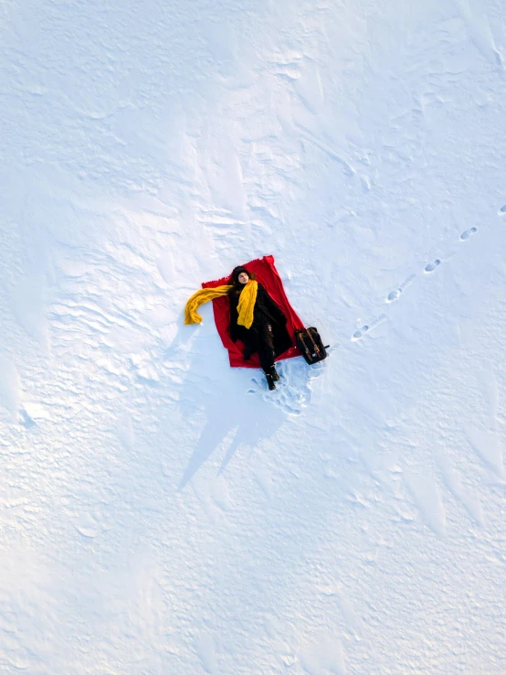 a man riding a snowboard down a snow covered slope, by Julia Pishtar, pexels contest winner, land art, top - down view, old cowboy in the arctic, inflatable, laying on the ground