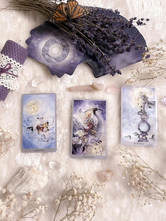 a bunch of cards sitting on top of a table, by Elaine Hamilton, fantasy art, purple, 3 winter deities, flatlay, lunar cycles