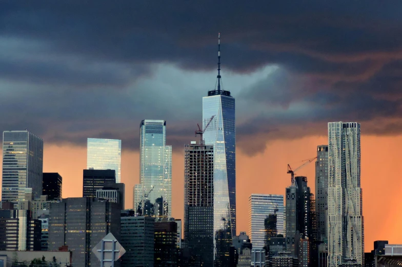 a view of the new york city skyline at sunset, pexels contest winner, hudson river school, turbulent storm clouds, 2022 photograph, tall metal towers, architecture photo