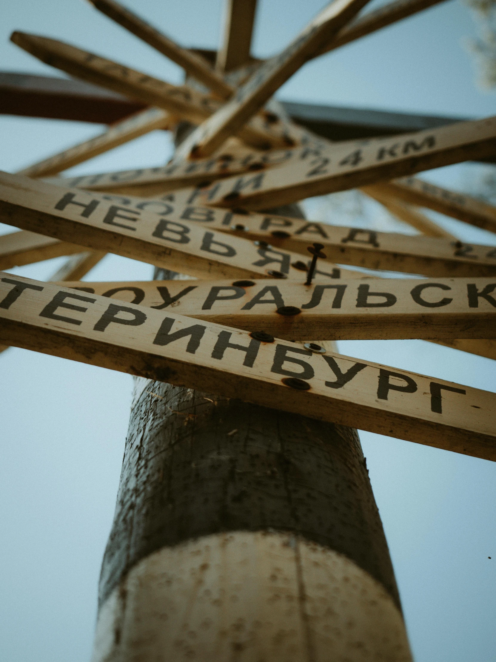 a pole with a bunch of wooden signs on it, by Attila Meszlenyi, unsplash, hyperdetailed photo, in russia, 🚿🗝📝