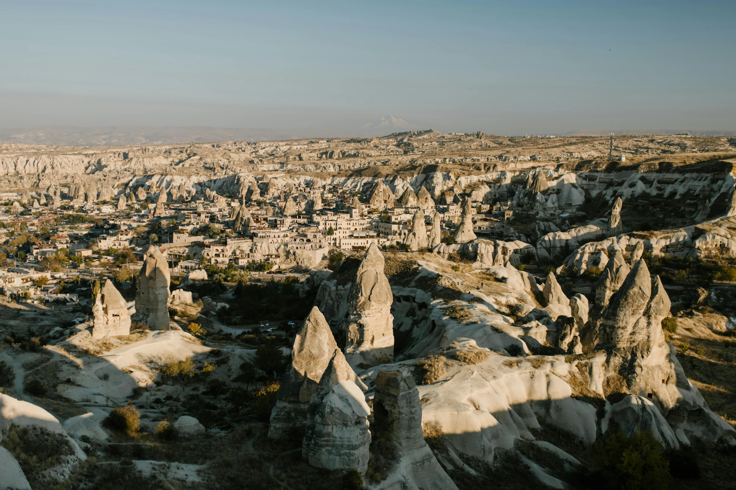 a person standing on top of a rock formation, pexels contest winner, art nouveau, black domes and spires, turkey, aerial view of an ancient land, youtube thumbnail