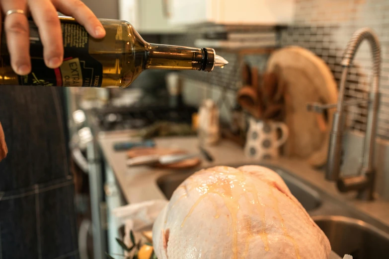 a person pouring wine into a turkey in a kitchen, by Matt Cavotta, profile image, olive oil, covered with organic flesh, rectangle