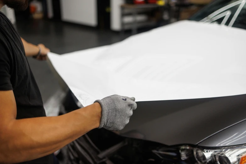 a man working on a car in a garage, a silk screen, unsplash, photorealism, anime car wrap, glossy white metal, close up angle, high quality paper