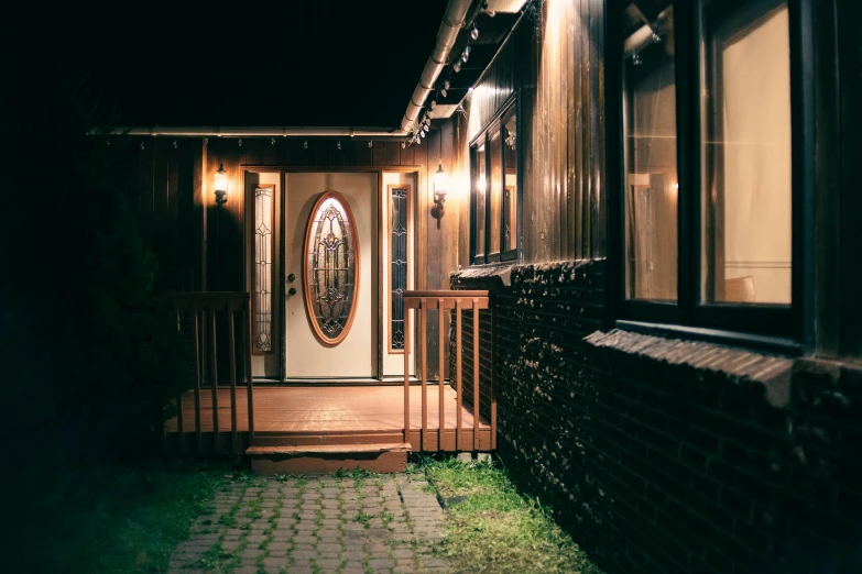 the front door of a house lit up at night, inspired by Elsa Bleda, unsplash, brown, cottage, chalet, side lighting