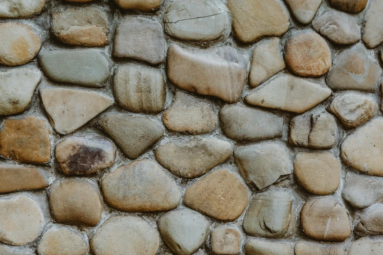 a fire hydrant sitting in front of a stone wall, a mosaic, pexels contest winner, natural skin tone 4k textures, ((rocks)), alessio albi, made of stone