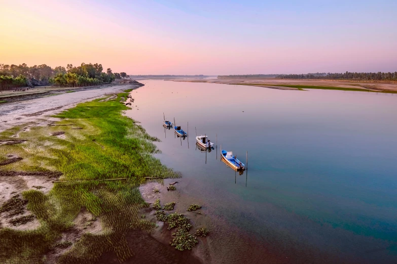 a group of boats floating on top of a body of water, by Eglon van der Neer, pexels contest winner, hurufiyya, paddy fields and river flowing, which shows a beach at sunset, bangladesh, beautiful panoramic imagery