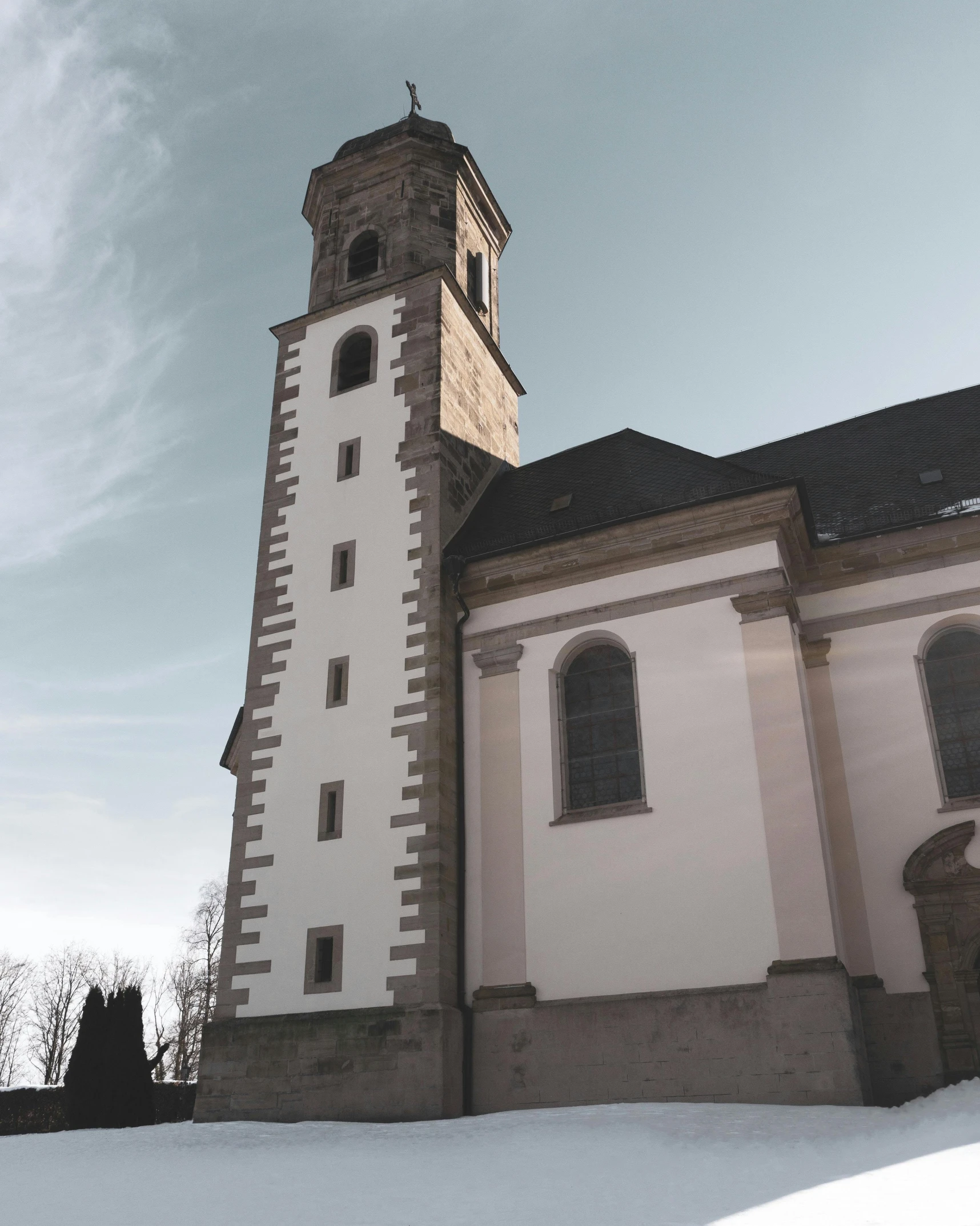 a large white building with a clock tower, inspired by Johann Ludwig Aberli, romanesque, dark gloomy church, winter, slightly sunny, trending photo