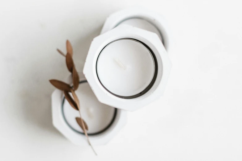 a white candle sitting on top of a white table, hexagonal ring, thumbnail, grey, random