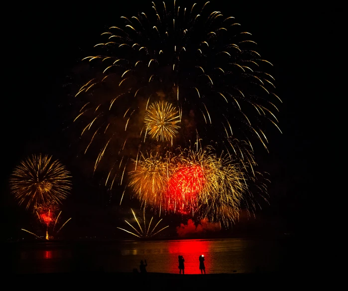 a couple of people standing in front of a firework, red+yellow colours, high-quality photo, award - winning photo ”, telephoto shot