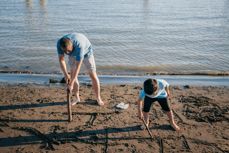 a man and a child are writing in the sand, unsplash, land art, the thames is dry, avatar image, maintenance photo, outdoor photo