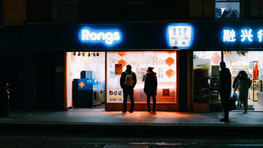 a group of people standing outside of a store at night, pexels contest winner, mingei, digital pong screen, the ringles, shop front, rags