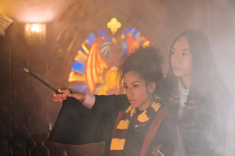 a couple of women standing next to each other, a picture, inspired by Hermione Hammond, pexels contest winner, hurufiyya, wizard casting a spell, scene set in a church, gemma chen, yellow magic theme