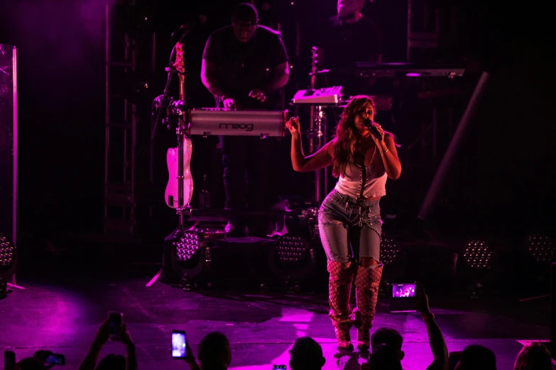 a woman standing on top of a stage holding a microphone, vanessa morgan, live concert lighting, sza, josh grover