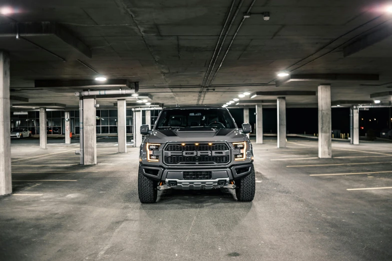 a pickup truck parked in a parking garage, unsplash, raptor, front lighting, stealthy, ford