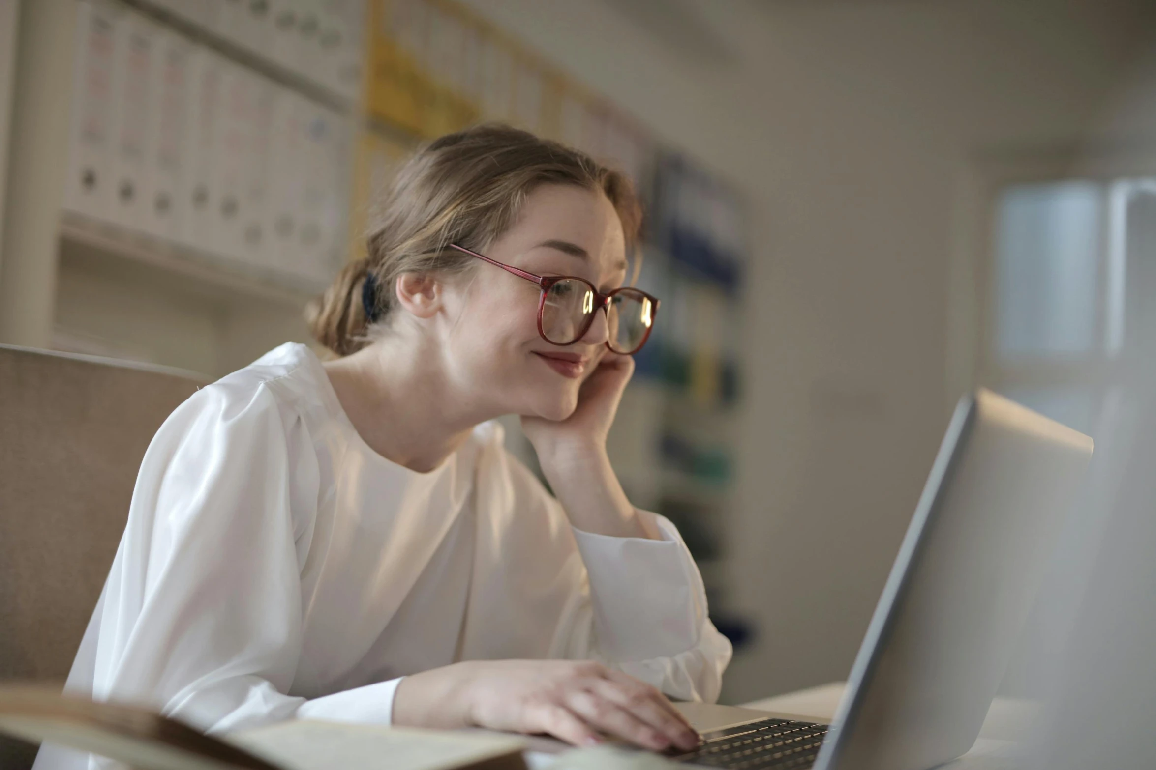 a woman sitting in front of a laptop computer, a picture, trending on pexels, nerd emoji, student, a very macular woman in white, supportive