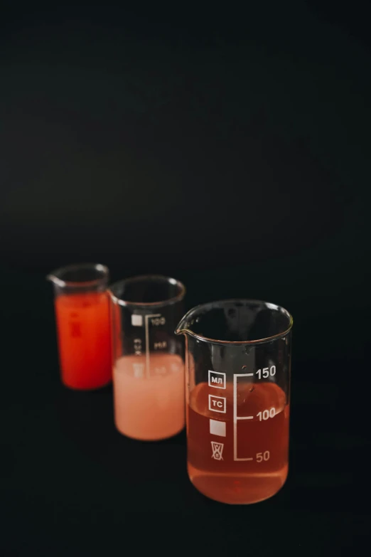 three beaks filled with liquid against a black background, unsplash, scientific glassware, faded red colors, juice, formulas
