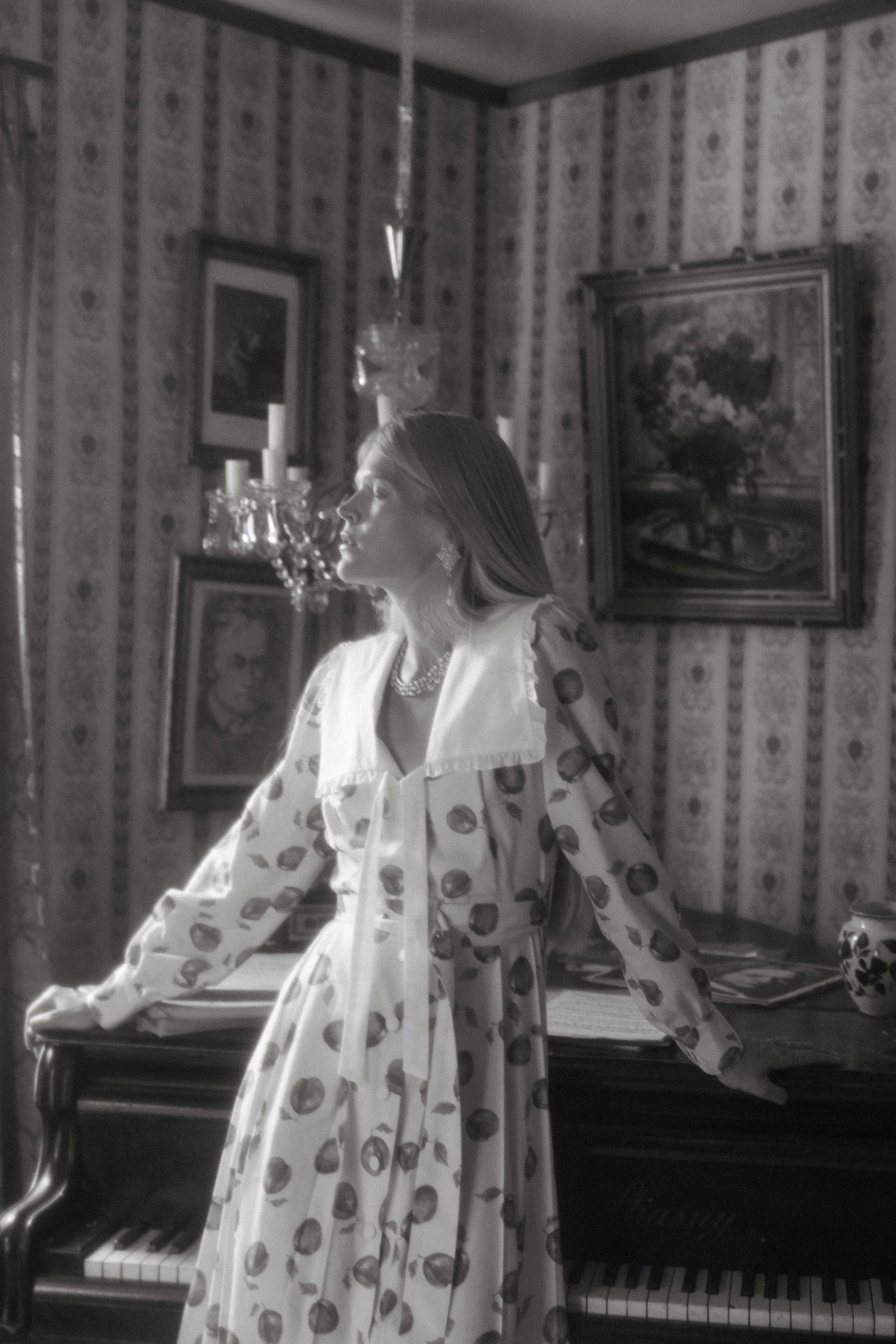 a woman standing in front of a piano, a black and white photo, inspired by Cecil Beaton, rococo, wearing a nightgown, video still, a blond, polka dot