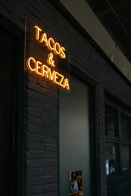 a neon sign that says tacos and cerveza on the side of a building, pexels, profile image, doorway, restaurant menu photo, portrait photo